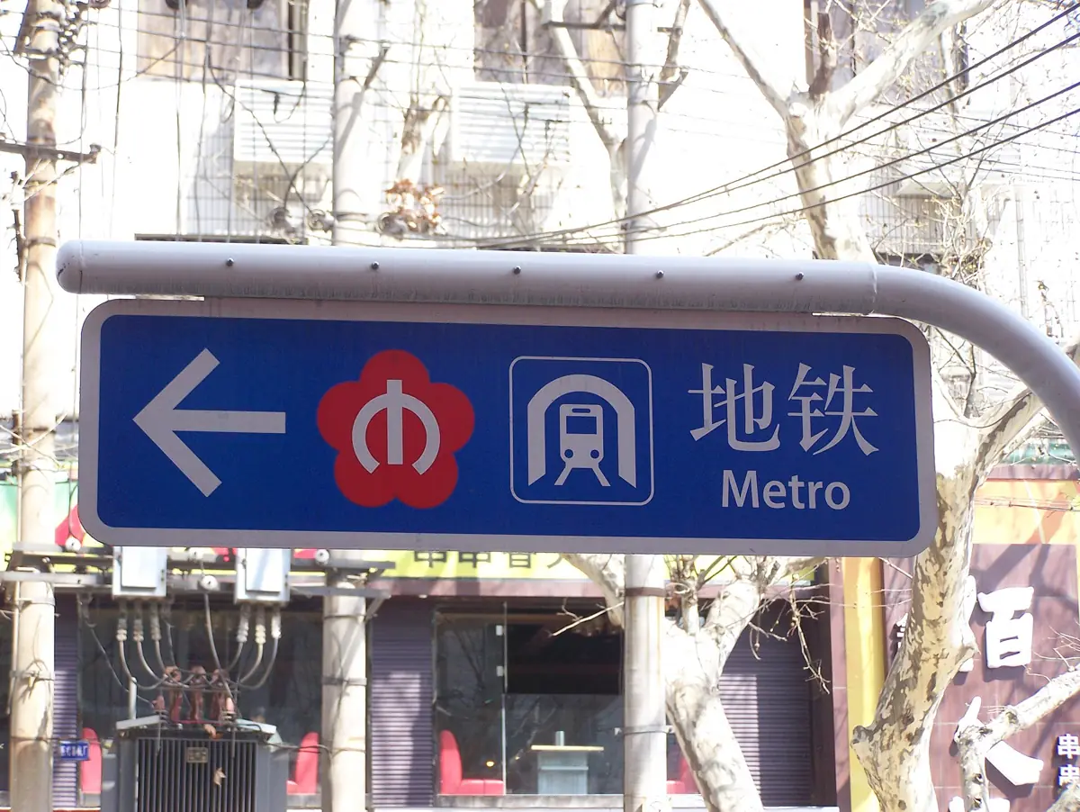 A blue Nanjing Metro sign with an arrow in Chinese and English