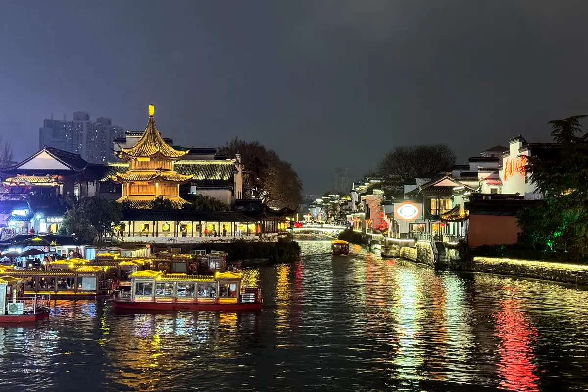 Lit-up boats and buildings along the Qinhuai River at night